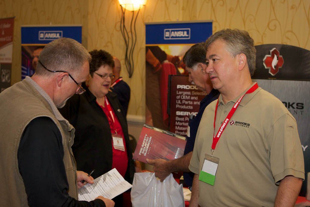 A group of people are standing in a room with a sign that says ' akg ' on it