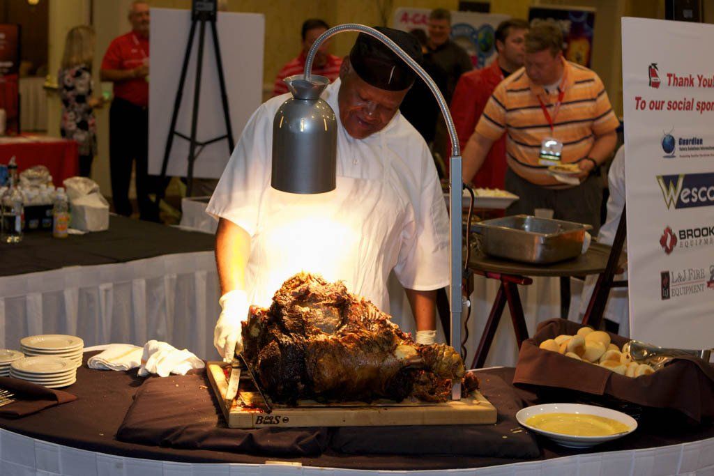 A man is cutting a large piece of meat on a cutting board
