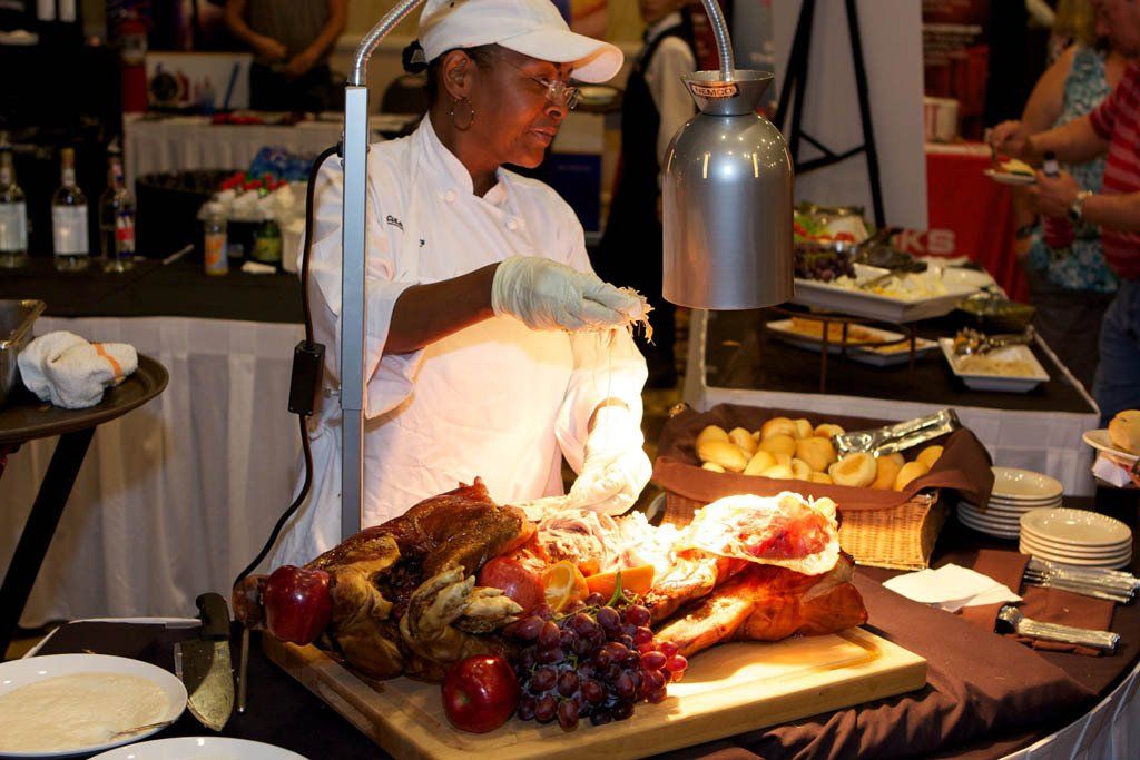 A chef is cutting a large piece of meat on a cutting board