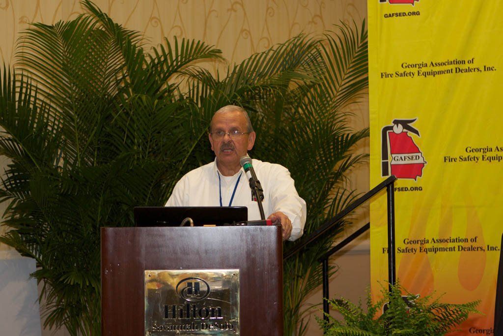 A man stands at a podium in front of a yellow banner that says georgia