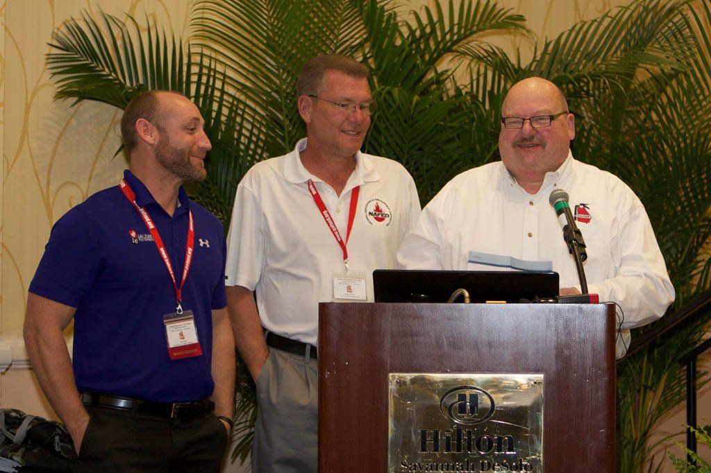 Three men are standing behind a podium that says hilton
