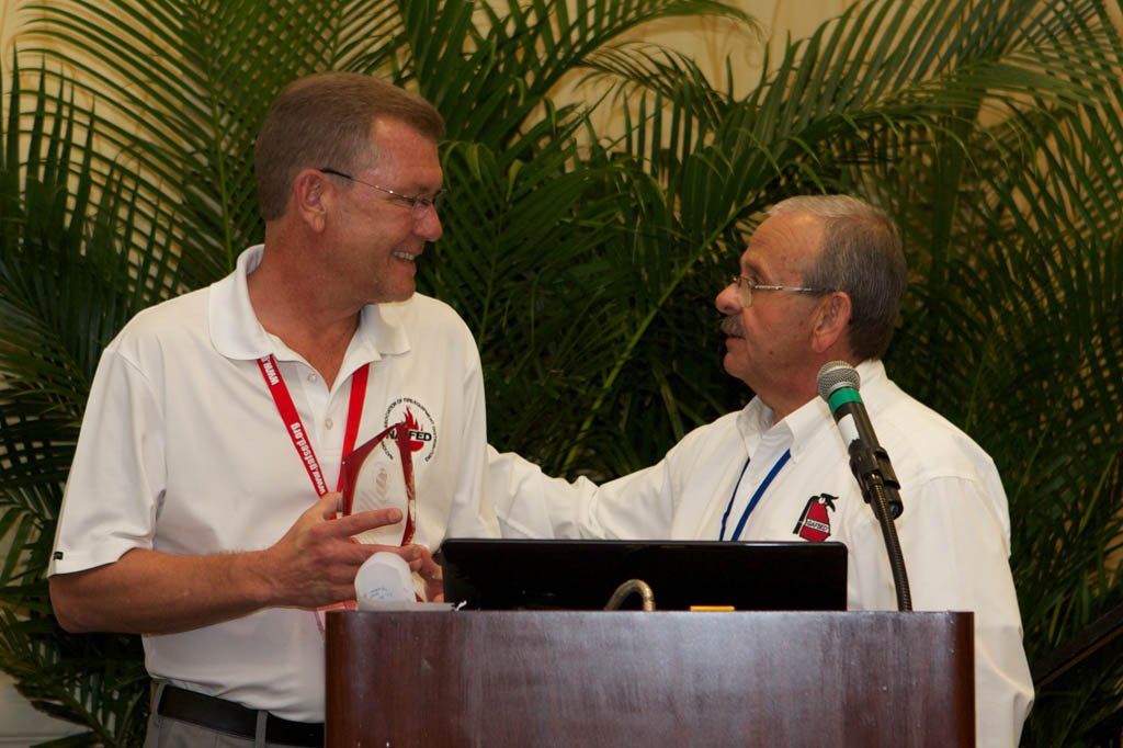 Two men are standing at a podium talking to each other