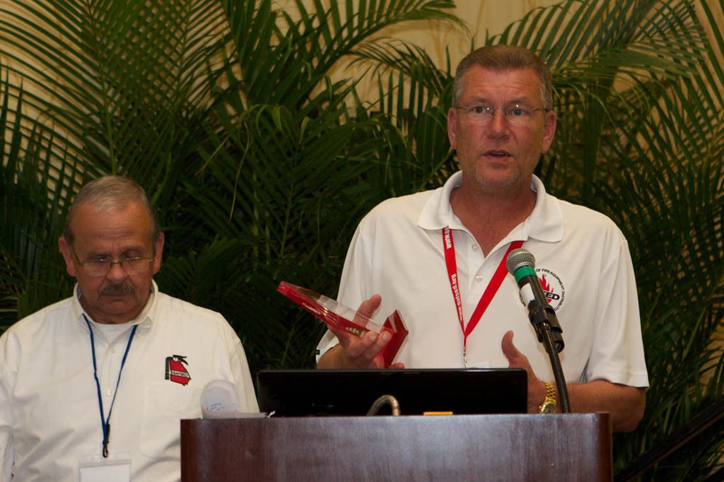 A man stands at a podium giving a presentation
