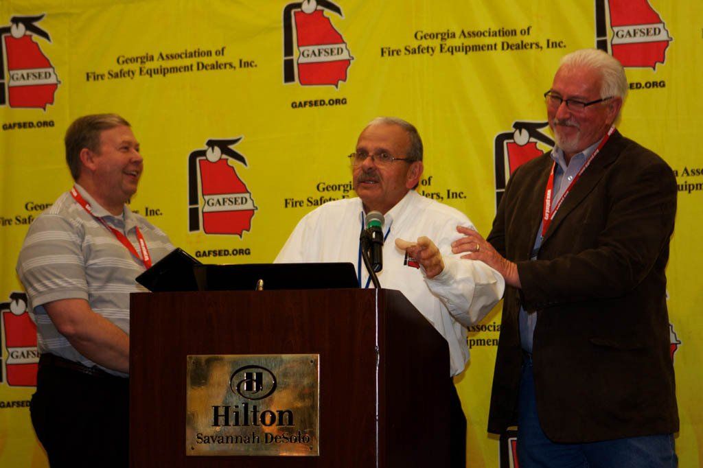 Three men standing in front of a podium that says hilton on it