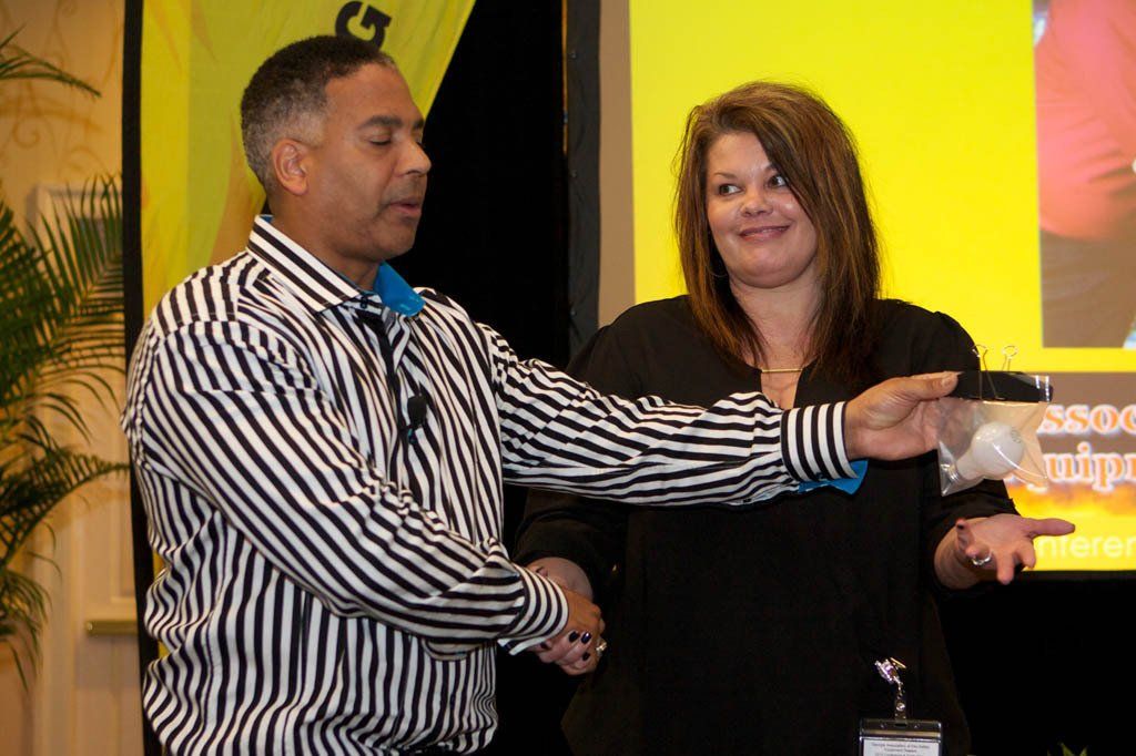 A man in a striped shirt is shaking hands with a woman
