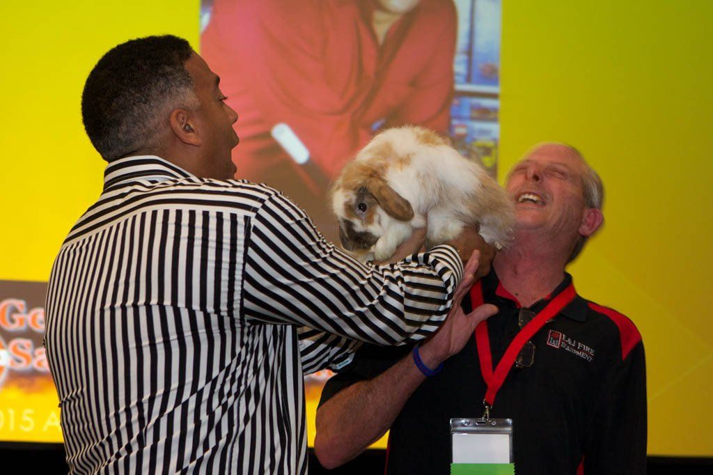 A man in a striped shirt is holding a small dog