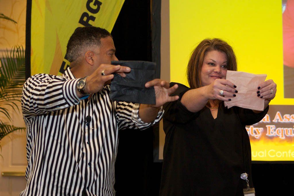 A man and a woman are holding a piece of paper in front of a sign that says rg