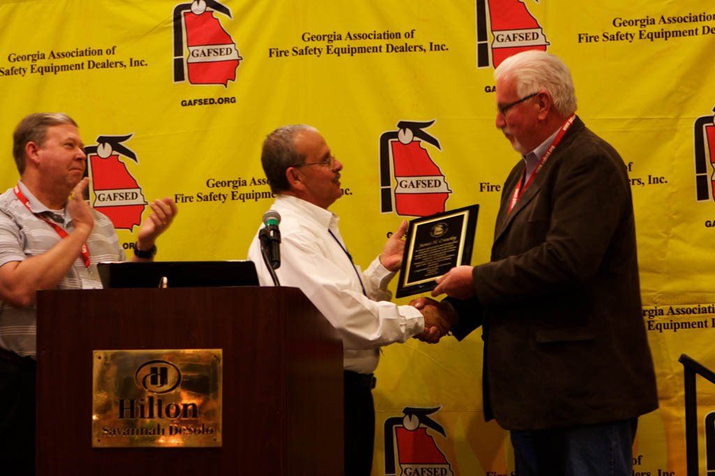 Two men shaking hands in front of a hilton sign