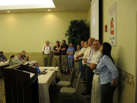 A group of people are standing around a podium in a room.