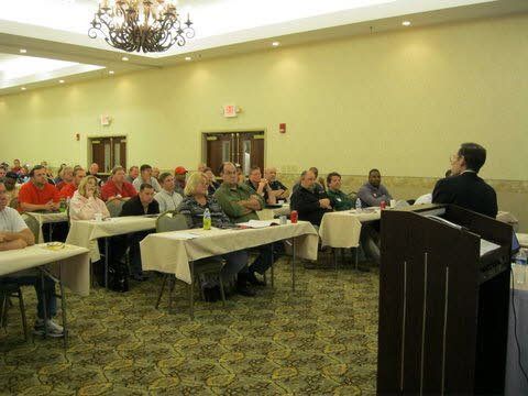 A man is giving a presentation to a group of people in a conference room.