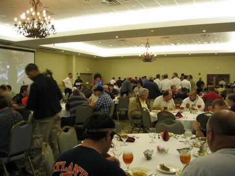 A large group of people are sitting at tables in a large room.