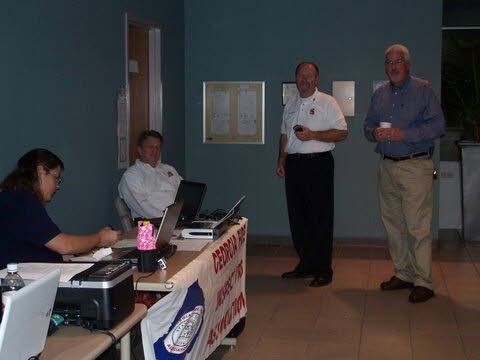 A group of people standing around a table with a sign that says tobacco free