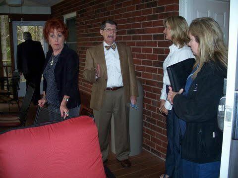 A group of people are standing in front of a brick wall.