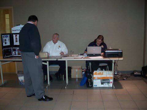 Two men and a woman are sitting at a table with laptops.