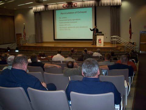 A man is giving a presentation to a group of people in an auditorium.