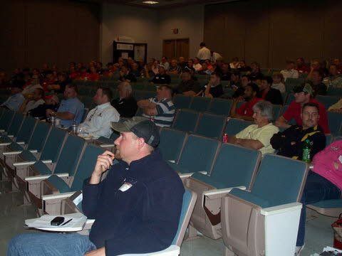 A group of people are sitting in an auditorium watching a presentation.
