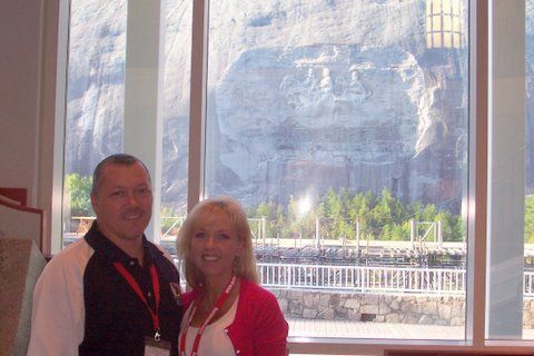 A man and a woman are standing in front of a window.