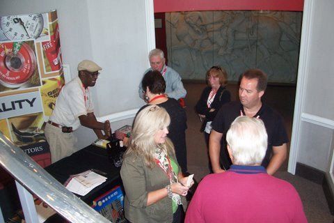A group of people standing in front of a sign that says quality