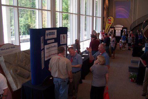 A group of people standing around a display board that says fossil