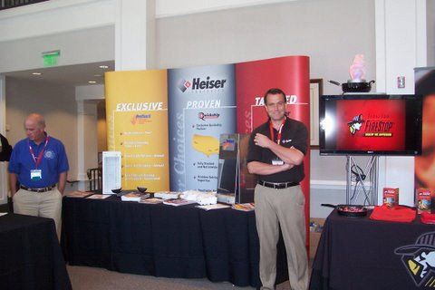A man stands in front of a table with a banner that says ' exclusive ' on it