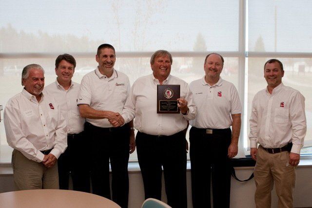A group of men standing next to each other holding a plaque