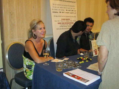 A woman sits at a table with a glass of wine