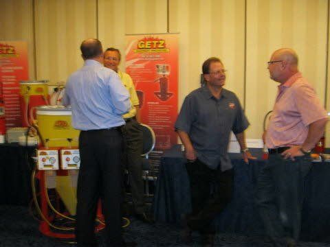 A group of men standing in front of a getz sign