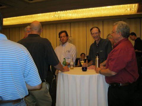 A group of men are standing around a table in a room.