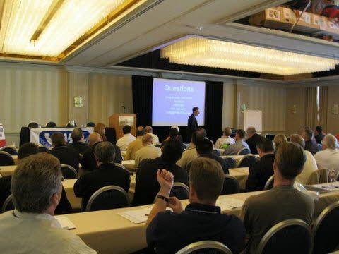 A man is giving a presentation to a group of people in a conference room