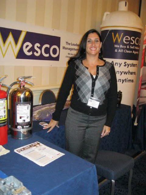 A woman stands in front of a wesco sign