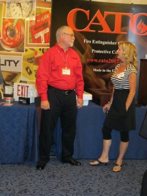 Two people standing in front of a catco sign
