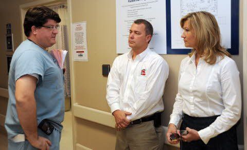 A group of people are standing in a hallway talking to each other