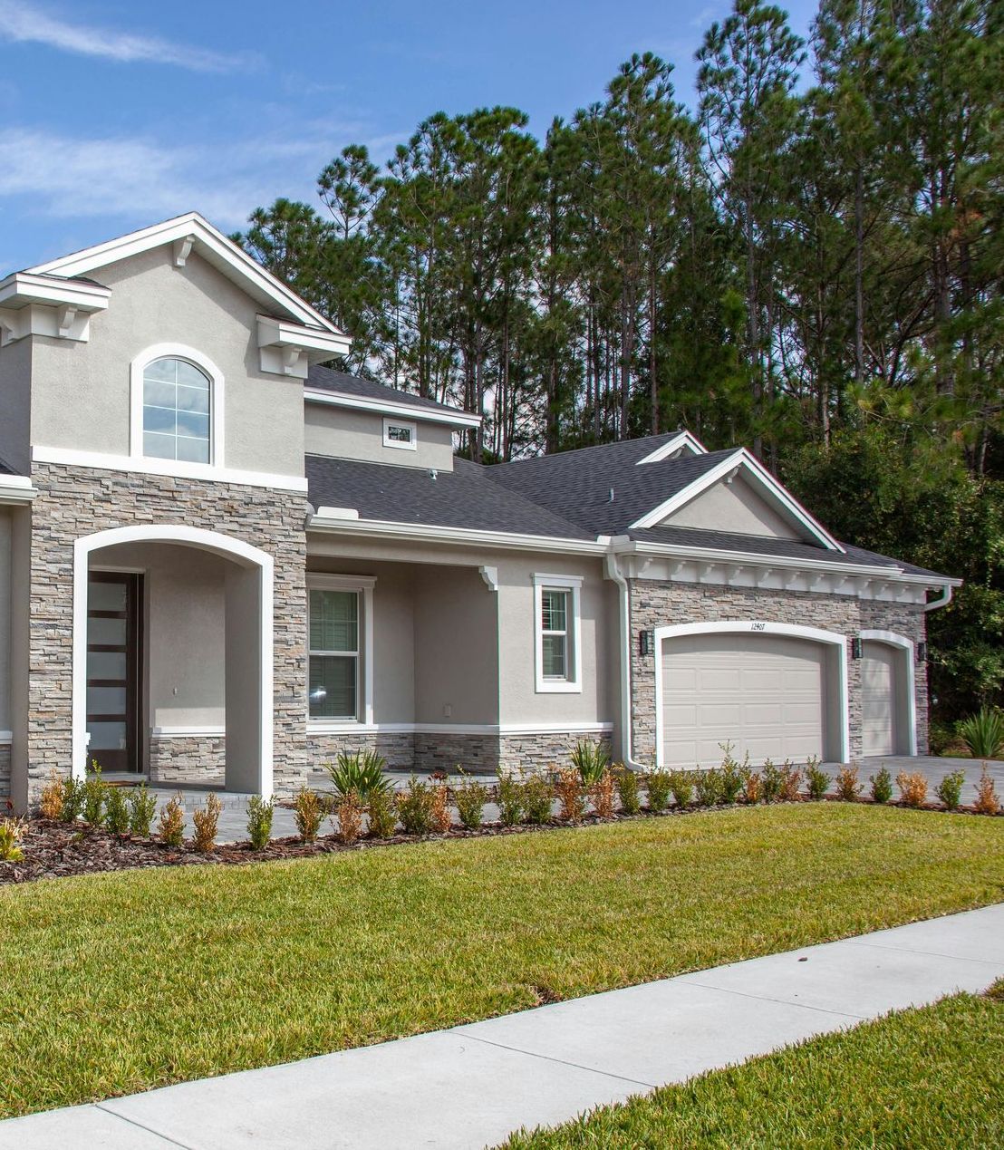 A house with two garages and a walkway in front of it
