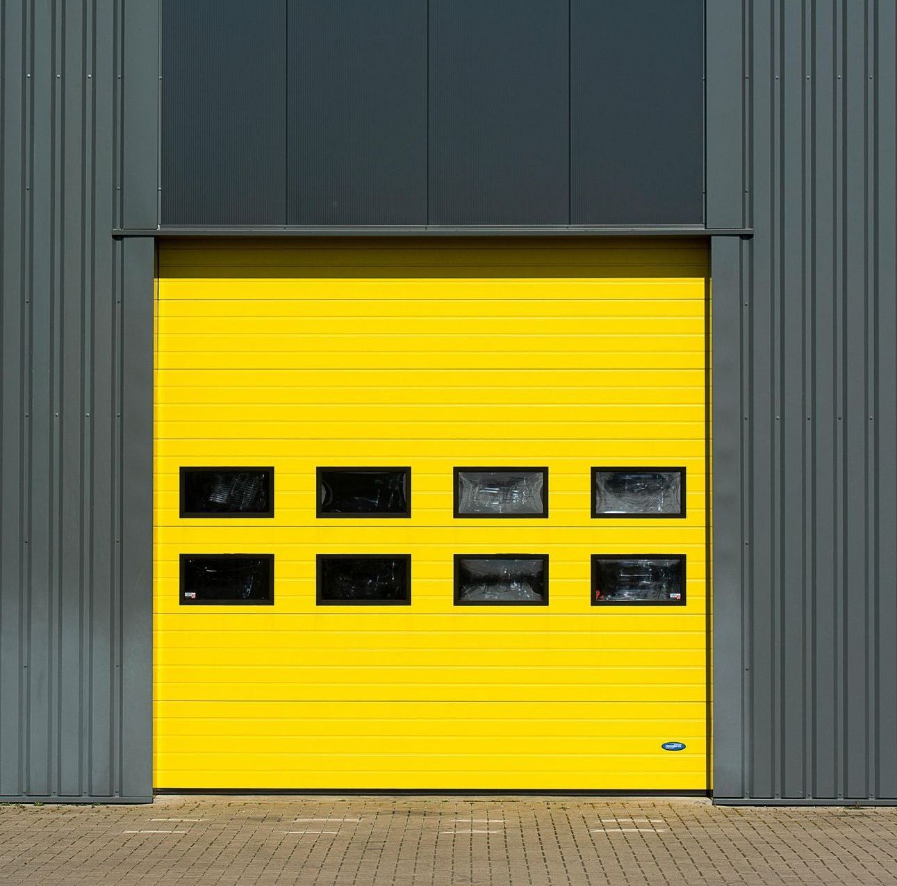 A yellow garage door is on the side of a building.