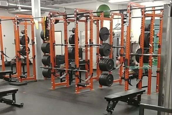 A gym with a lot of weights and benches