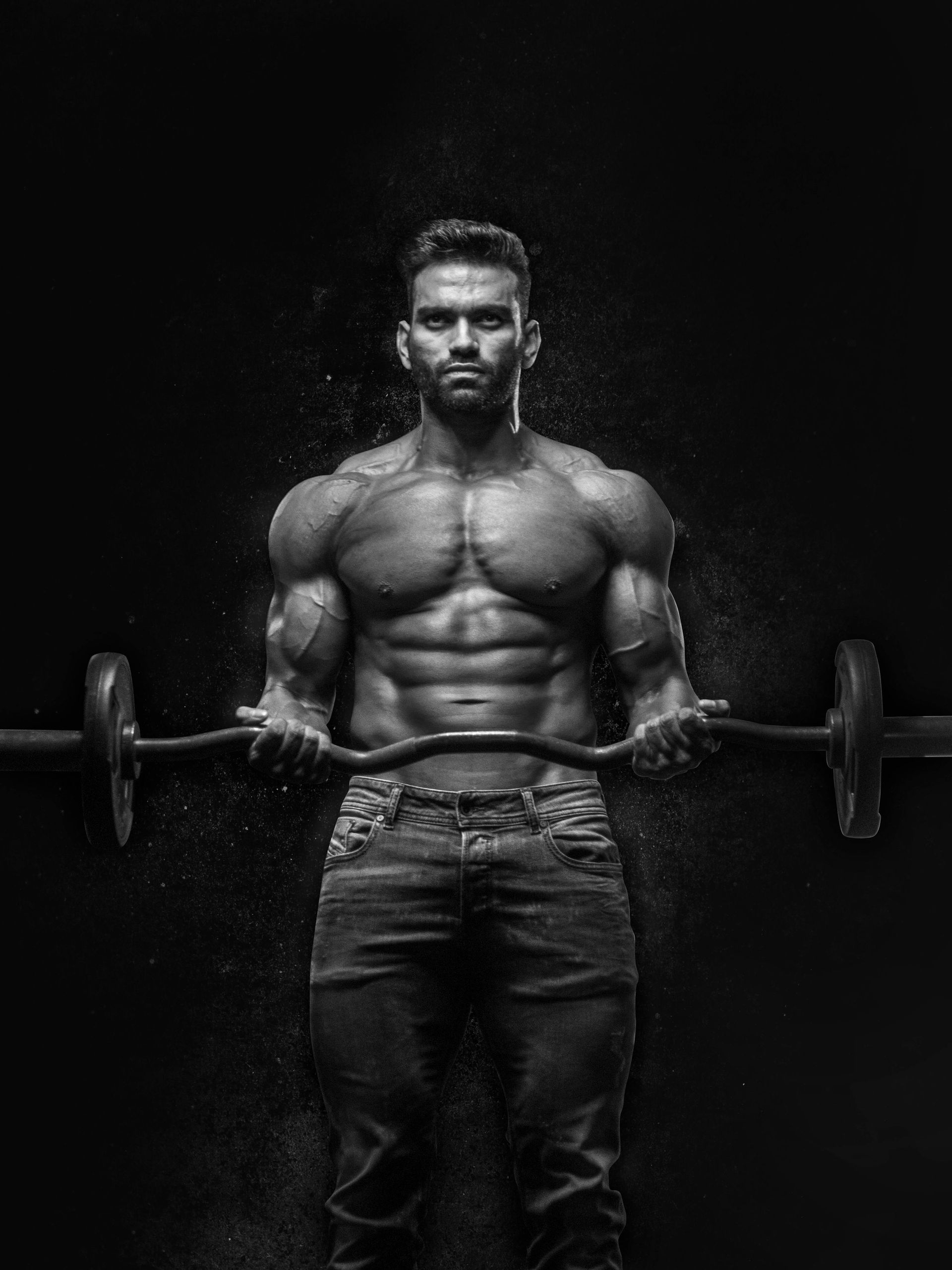 A man is lifting a barbell in a black and white photo.