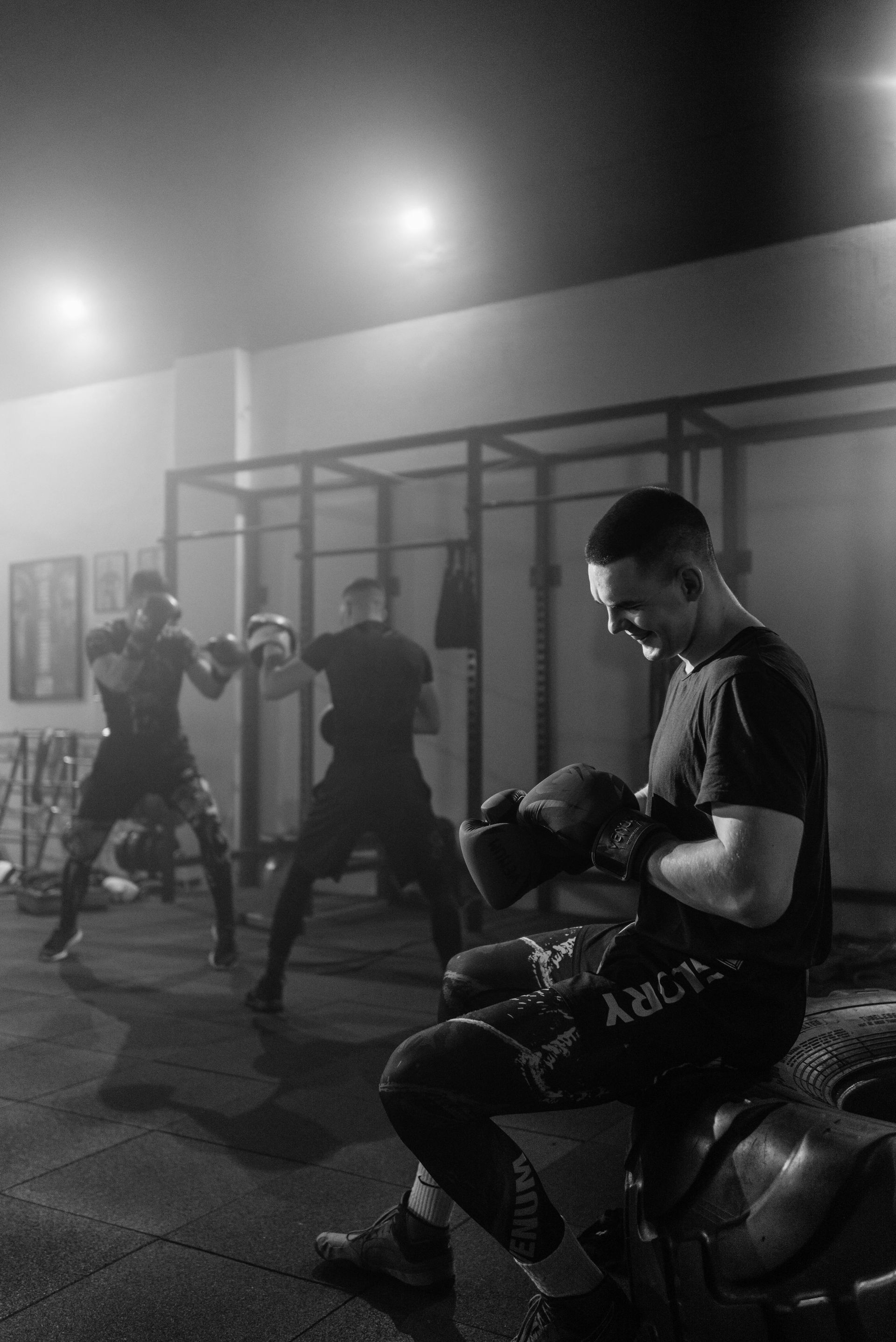 A group of men are boxing in a gym at night.