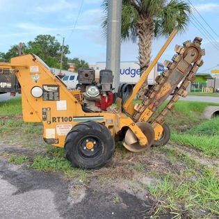 A yellow trencher is parked on the side of the road.