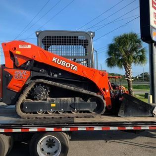 A kubota skid steer is sitting on top of a trailer.