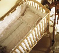 A wooden crib is sitting in a room next to a table.