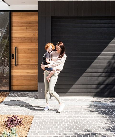 Women And Child in front of Garage Door — Wind Rated Sectional Doors in Cairns, QLD