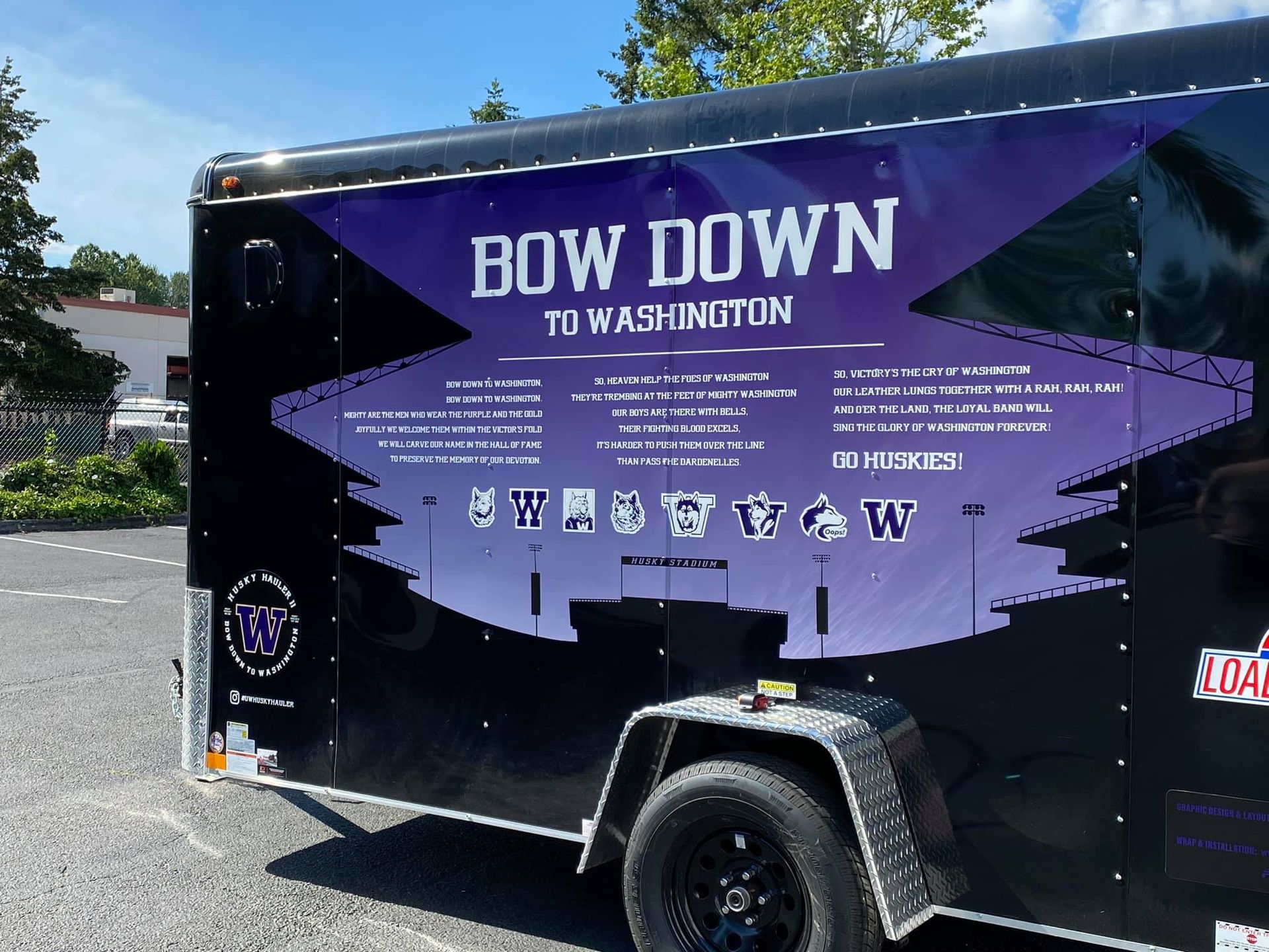 A black trailer featuring purple graphics with 