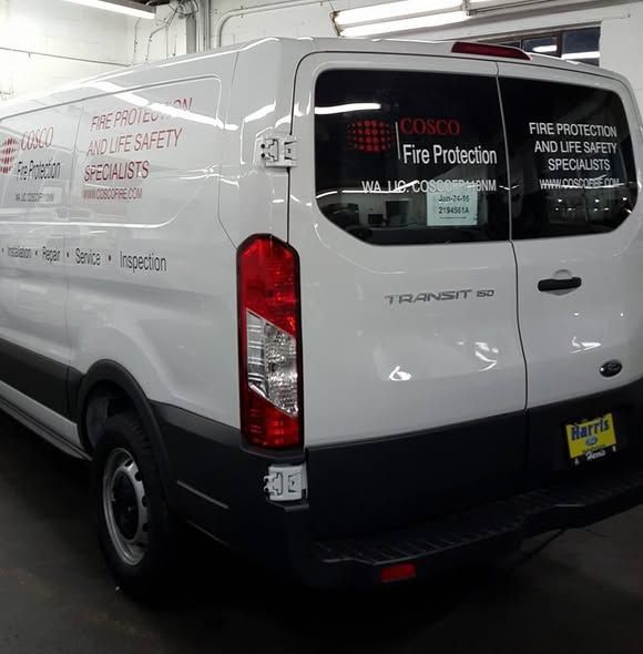 A white Ford Transit work van branded with 