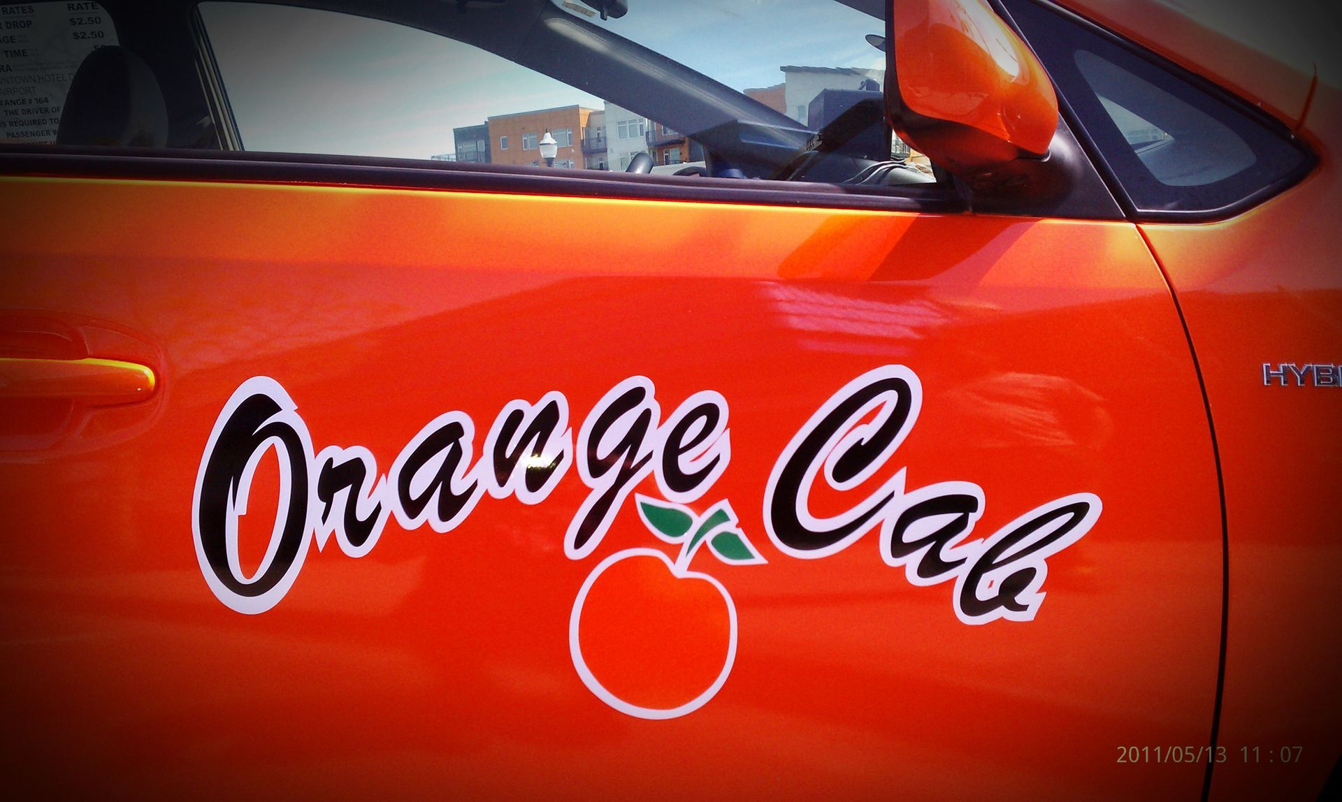 A close-up view of the side of an orange car featuring a stylized 