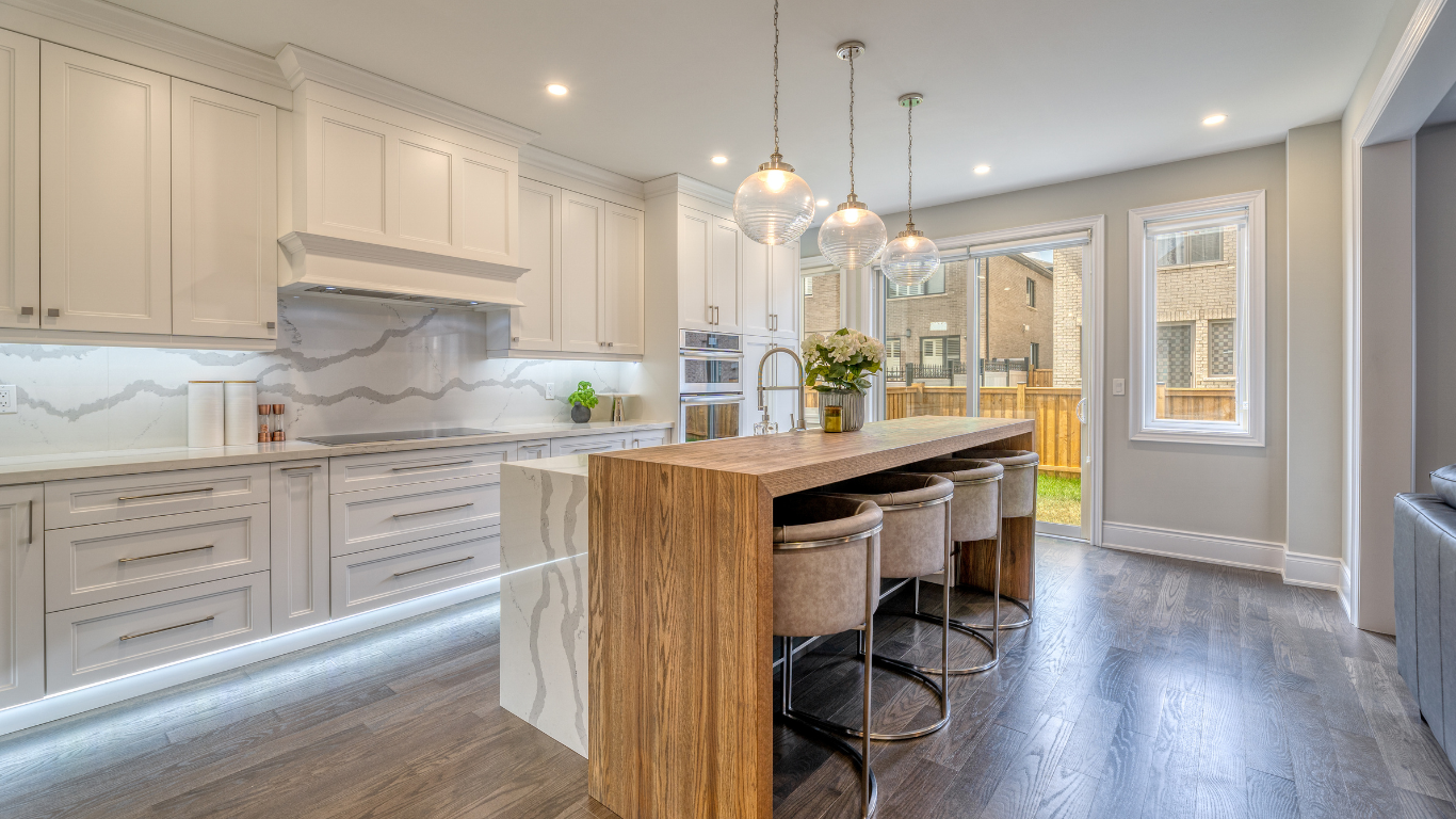 A kitchen with white cabinets and a wooden island.