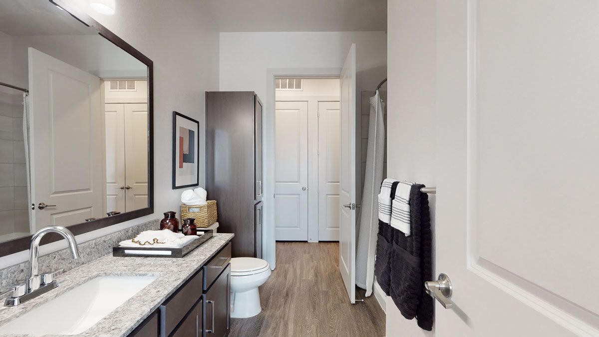 A bathroom with a sink , toilet and mirror.