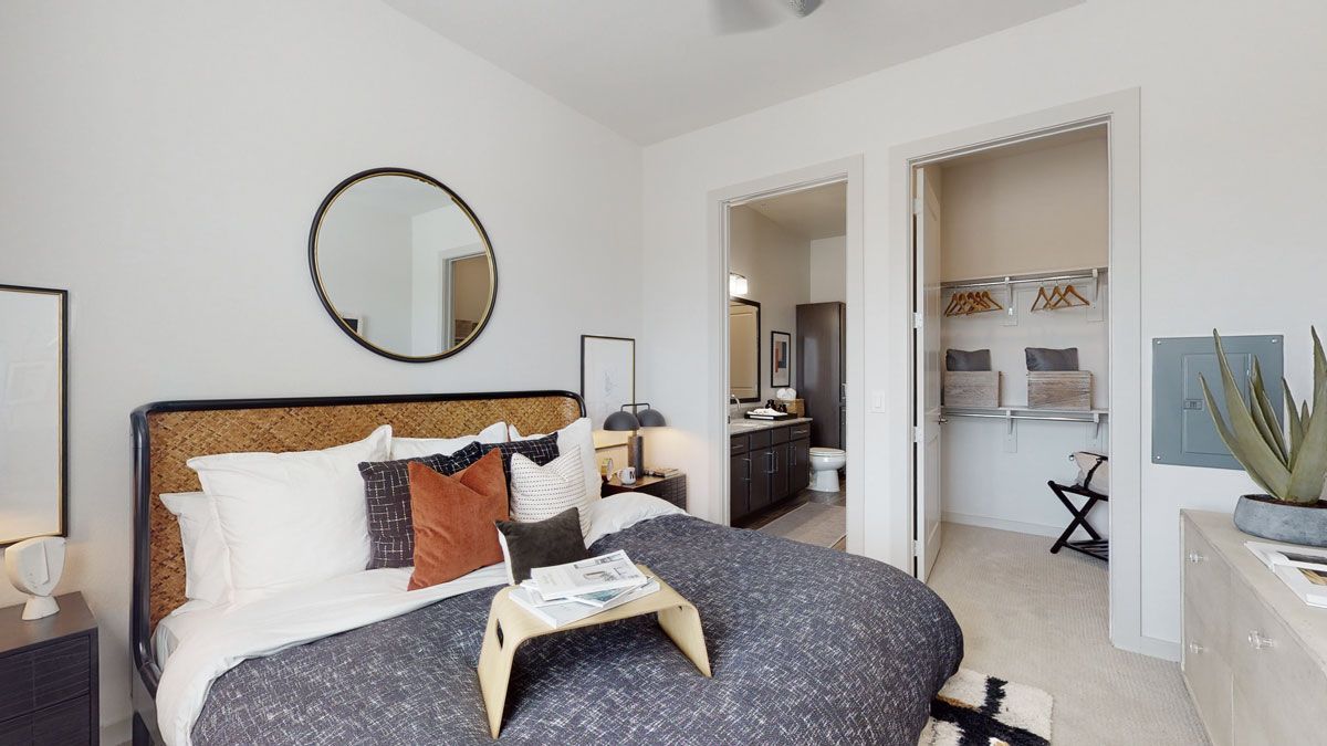 A bedroom with a large bed and a mirror on the wall.