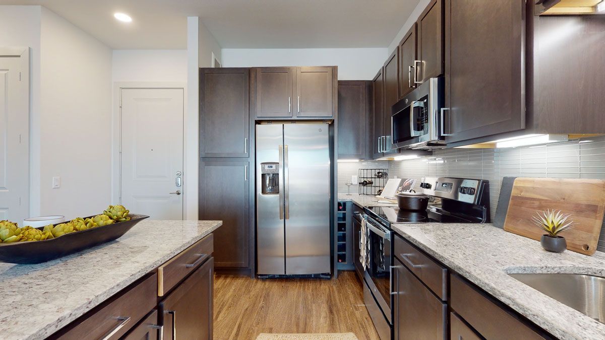 A kitchen with stainless steel appliances and granite counter tops.