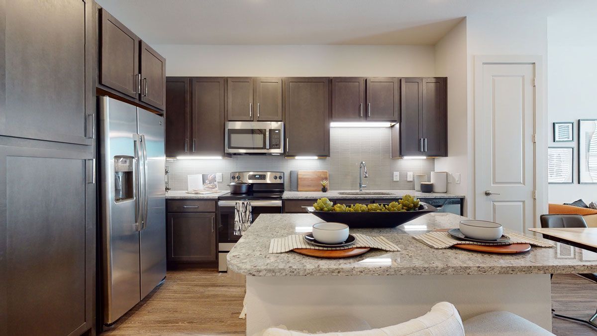 A kitchen with stainless steel appliances and granite counter tops.