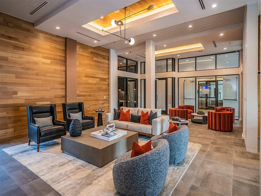 A living room with a couch , chairs , and a coffee table.